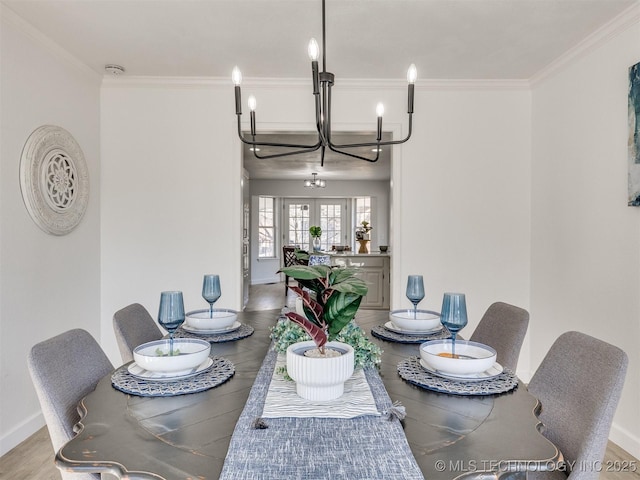 dining area with french doors, an inviting chandelier, crown molding, and hardwood / wood-style floors