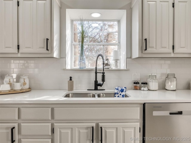 kitchen featuring backsplash, dishwasher, white cabinets, and sink