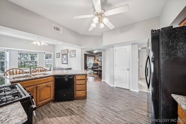 kitchen featuring black appliances, ceiling fan, dark hardwood / wood-style flooring, and light stone countertops