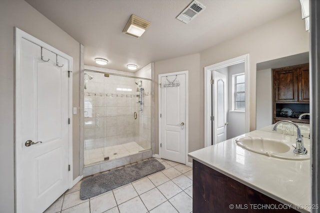 bathroom featuring vanity, tile patterned floors, and walk in shower