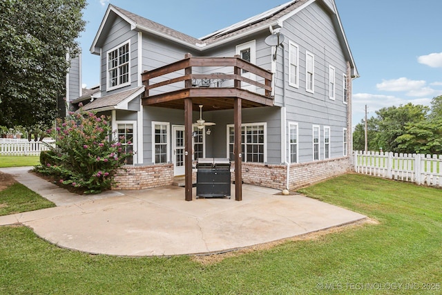 back of house with a lawn, a patio, and a wooden deck