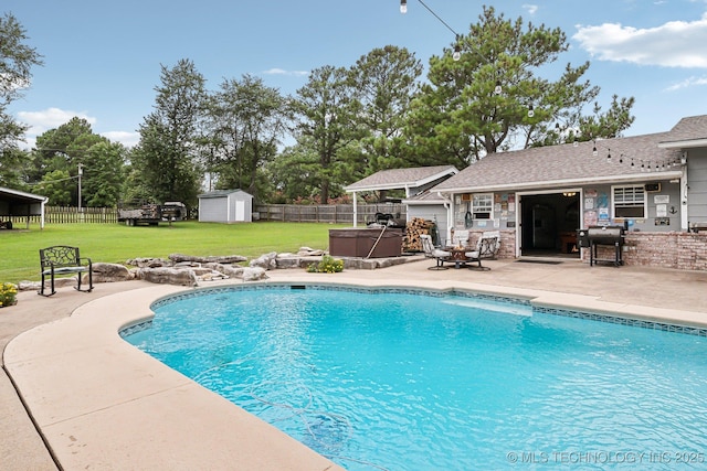 view of swimming pool with a yard, a hot tub, grilling area, a storage shed, and a patio