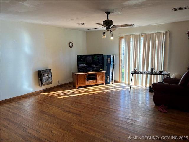 living room with heating unit, hardwood / wood-style flooring, and ceiling fan