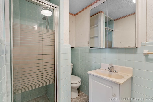 bathroom featuring an enclosed shower, vanity, toilet, and a textured ceiling