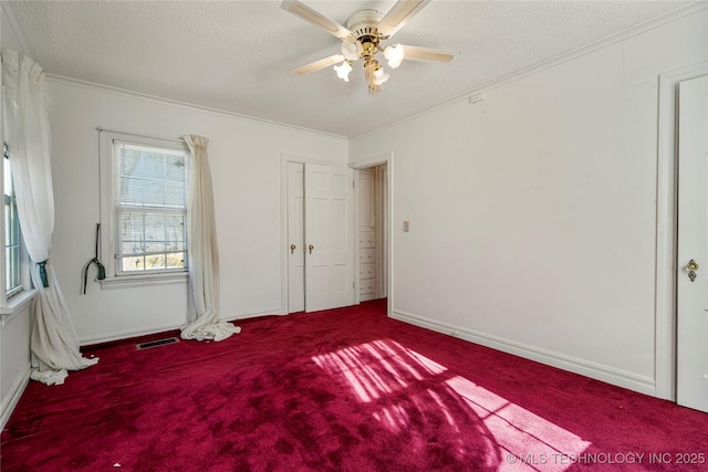 unfurnished bedroom with carpet, a textured ceiling, ceiling fan, and crown molding