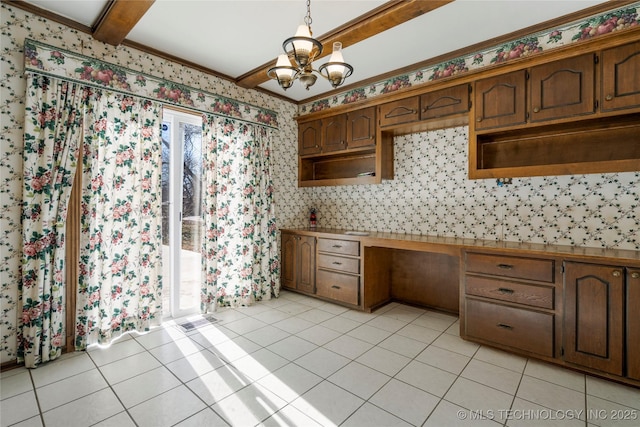 kitchen with pendant lighting, an inviting chandelier, ornamental molding, light tile patterned floors, and beamed ceiling