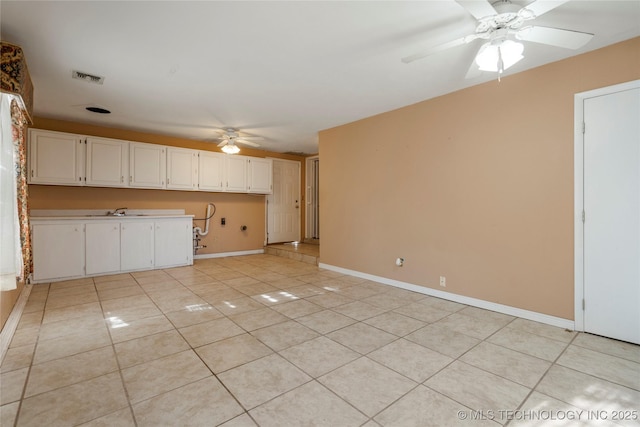 kitchen featuring light tile patterned floors, white cabinetry, ceiling fan, and sink