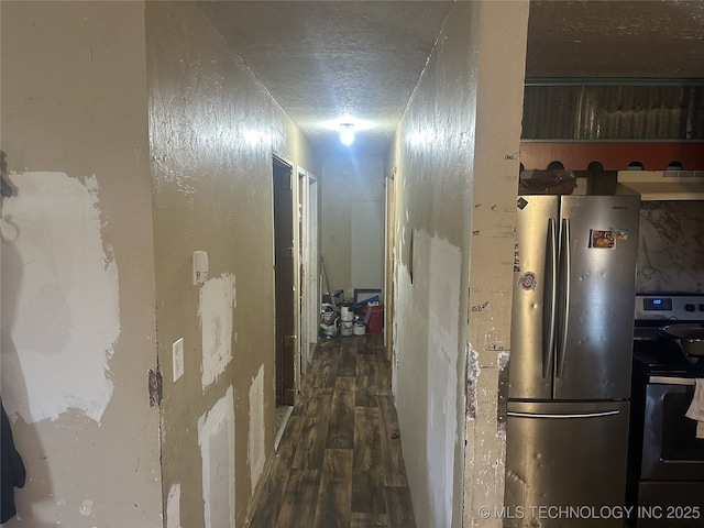 hall with dark hardwood / wood-style floors and a textured ceiling