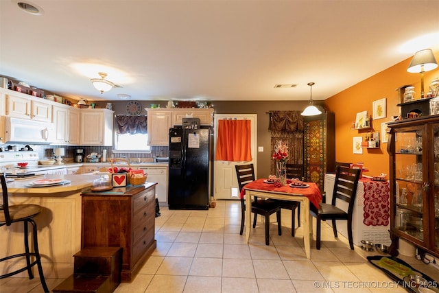 kitchen featuring light tile patterned floors, hanging light fixtures, and white appliances