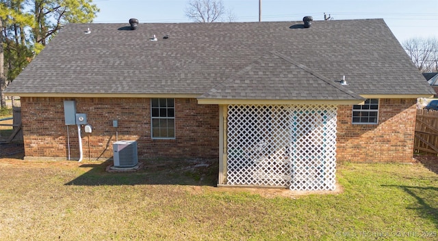 rear view of property featuring a yard and cooling unit