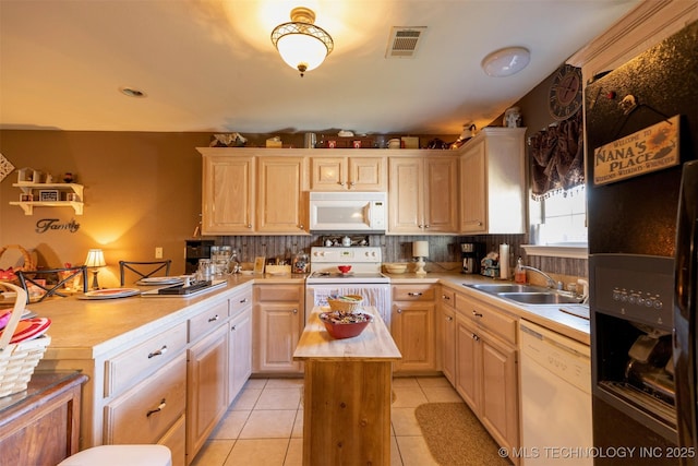 kitchen featuring light brown cabinetry, white appliances, sink, light tile patterned floors, and a center island