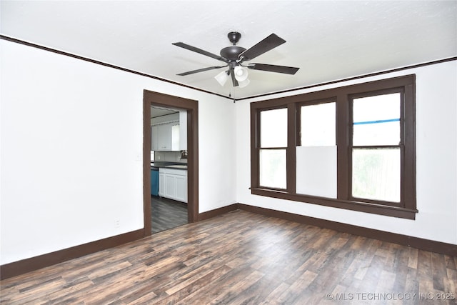 empty room featuring dark hardwood / wood-style floors, ceiling fan, a healthy amount of sunlight, and crown molding