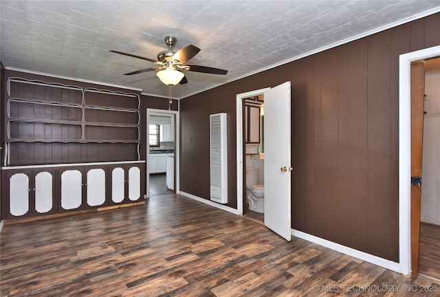 unfurnished bedroom featuring ensuite bathroom, ceiling fan, dark hardwood / wood-style floors, and ornamental molding