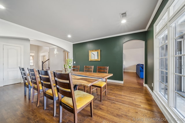 dining space with crown molding and wood-type flooring