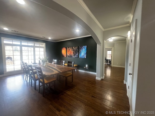 dining area featuring dark hardwood / wood-style floors, a wealth of natural light, and crown molding