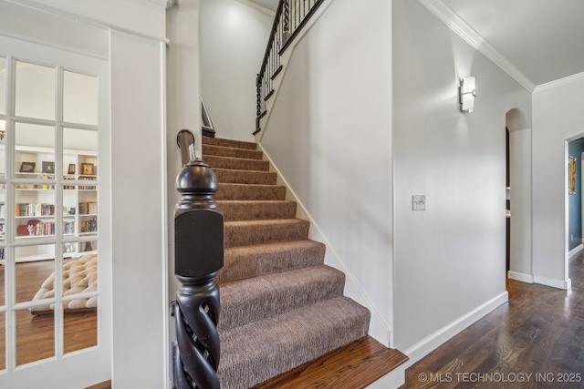 stairway with hardwood / wood-style flooring and crown molding