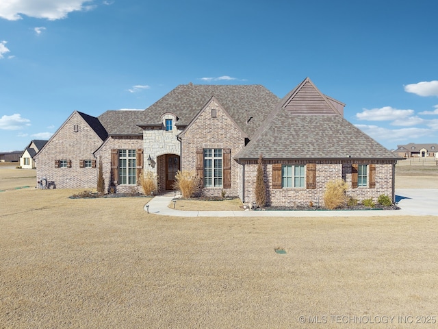 french country home featuring a front yard