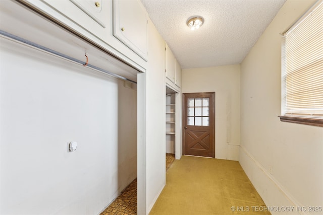 doorway to outside with a textured ceiling