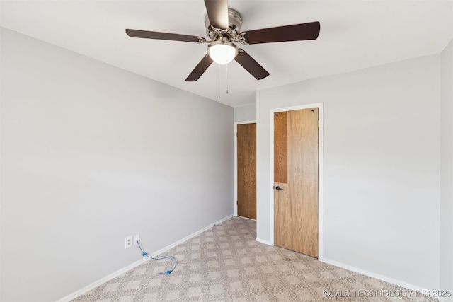 carpeted spare room featuring ceiling fan