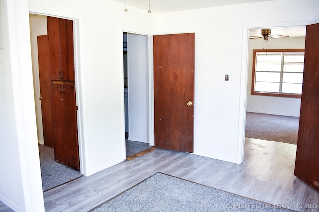 empty room with light hardwood / wood-style floors and ceiling fan