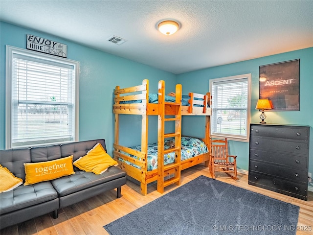 bedroom with hardwood / wood-style flooring and a textured ceiling