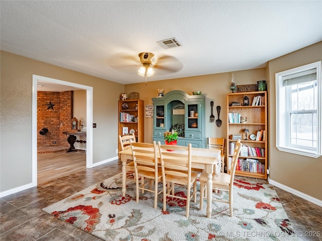 dining room featuring ceiling fan and a textured ceiling