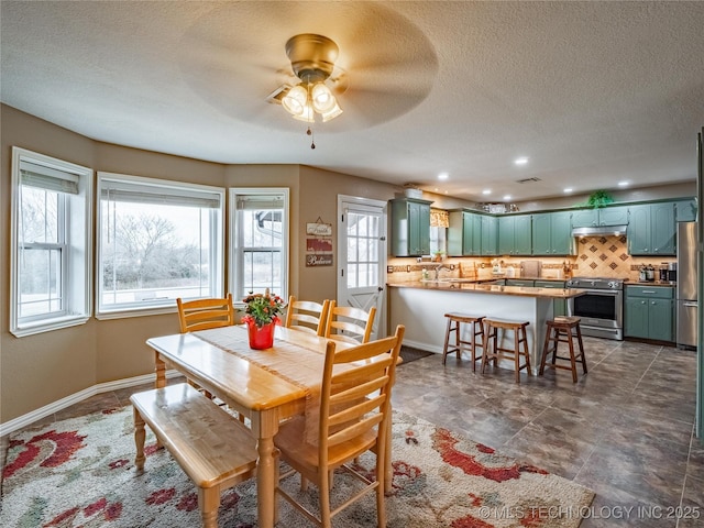 dining area with ceiling fan and a textured ceiling