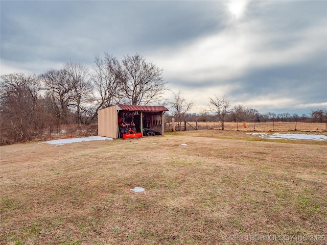 view of yard featuring an outdoor structure and a rural view