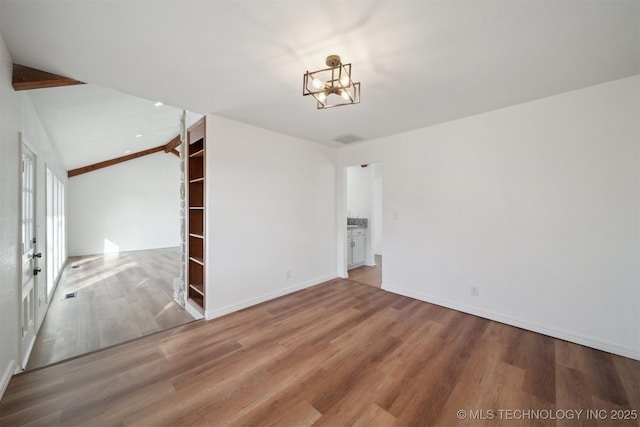 empty room with a notable chandelier, lofted ceiling with beams, and wood-type flooring