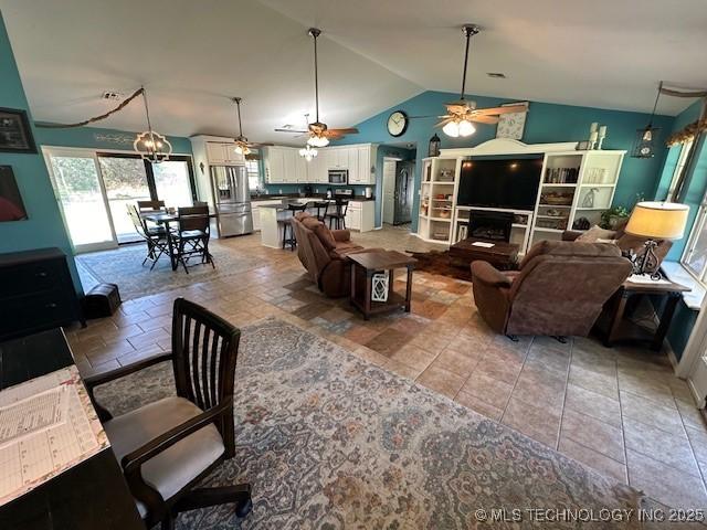 living room featuring tile patterned flooring, ceiling fan, and lofted ceiling