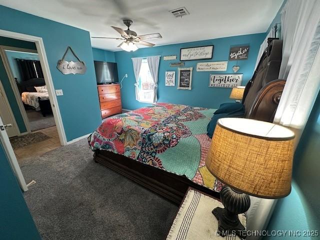 bedroom featuring ceiling fan and dark carpet