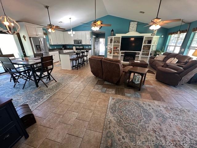 living room featuring ceiling fan and vaulted ceiling