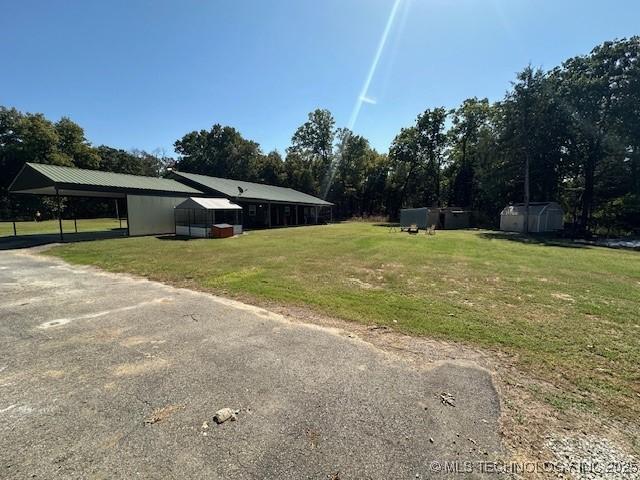 view of yard featuring a carport and an outbuilding