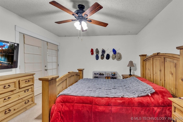 bedroom featuring a closet, carpet flooring, a textured ceiling, and ceiling fan