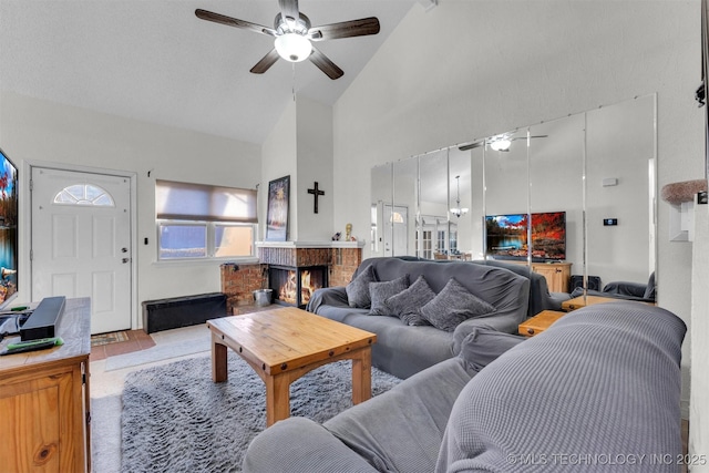 living room featuring high vaulted ceiling, a brick fireplace, and ceiling fan