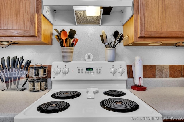 interior details with white electric range and wall chimney exhaust hood