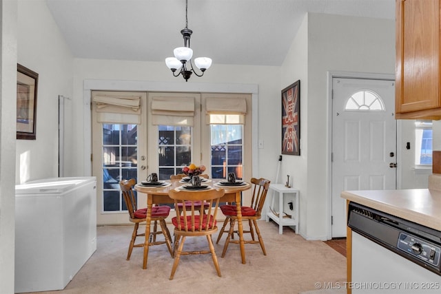 carpeted dining room with french doors, a chandelier, and a healthy amount of sunlight