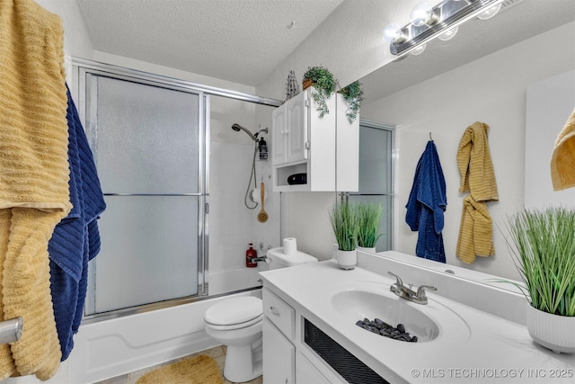 full bathroom with tile patterned flooring, toilet, vanity, bath / shower combo with glass door, and a textured ceiling