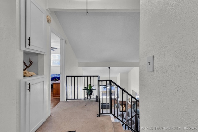 hallway with lofted ceiling and light carpet