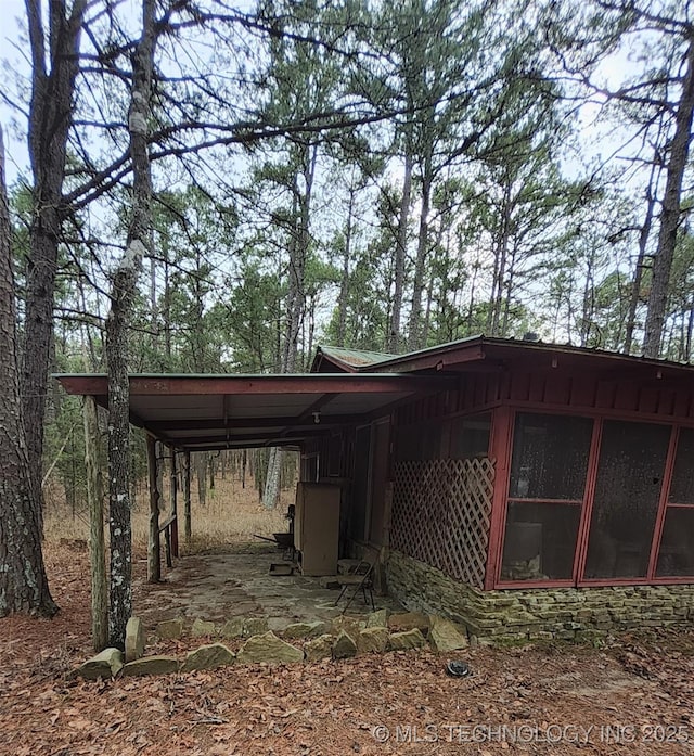 view of home's exterior with a carport and a sunroom