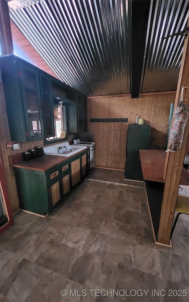 kitchen featuring beam ceiling, white electric stove, wooden walls, and sink