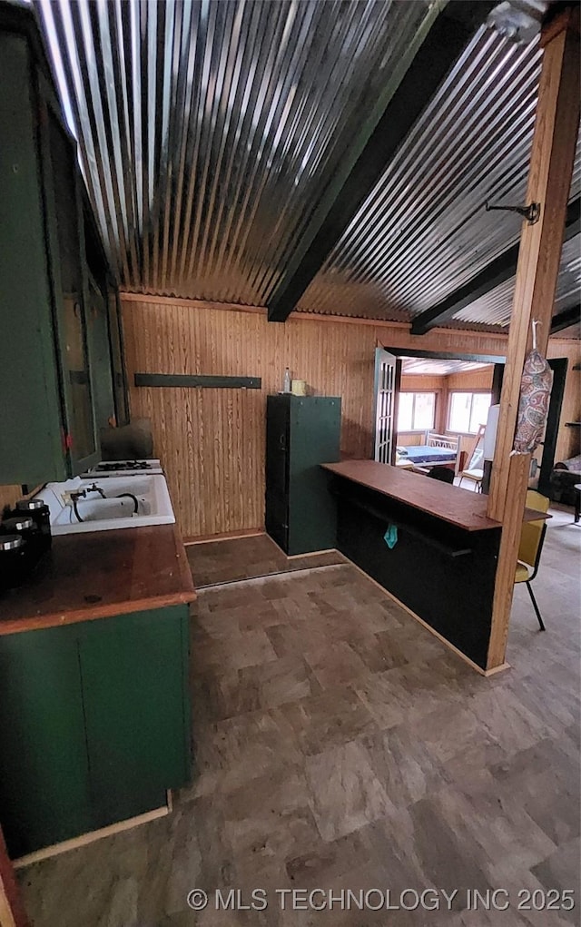 interior space with wood walls and beam ceiling