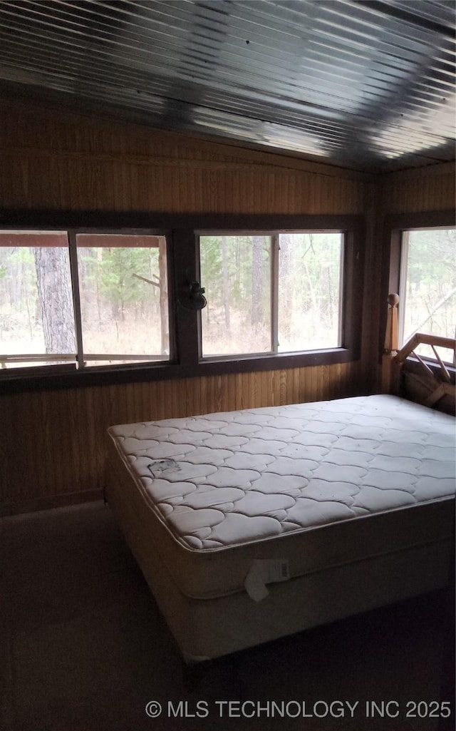 unfurnished bedroom featuring wood walls