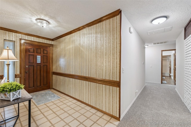 carpeted foyer featuring crown molding and a textured ceiling