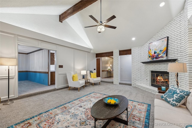 living room with carpet flooring, vaulted ceiling with beams, ceiling fan, and a brick fireplace