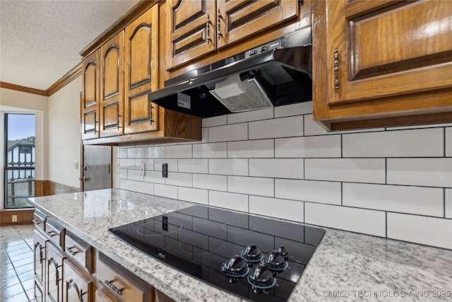 kitchen with black electric stovetop, crown molding, light stone countertops, a textured ceiling, and light tile patterned flooring