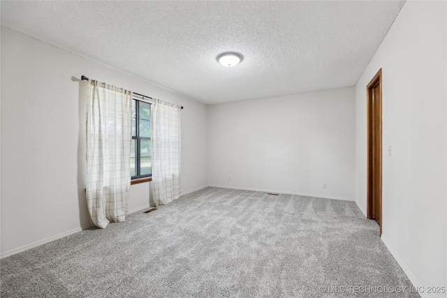 unfurnished room featuring carpet flooring and a textured ceiling