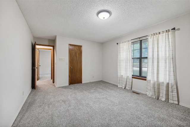 unfurnished bedroom with carpet floors, a textured ceiling, and a closet