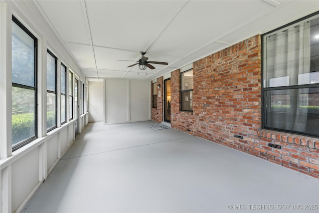 unfurnished sunroom with ceiling fan