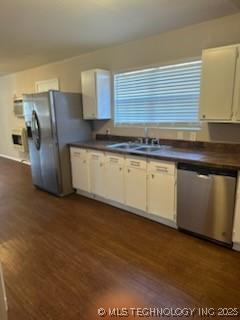 kitchen with sink, dark hardwood / wood-style flooring, white cabinets, and appliances with stainless steel finishes